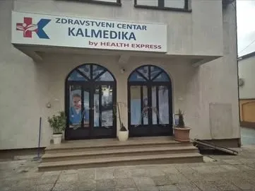 Tabla Zdravstvenog centra Kalmedika sa crveno-plavim logom iznad lučnih ulaznih vrata